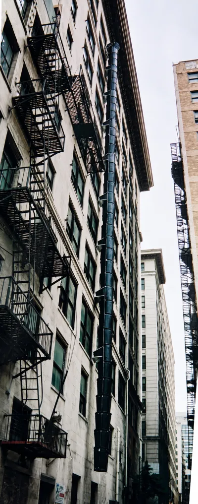 Buckets stacked vertically on a building's exterior for debris disposal.